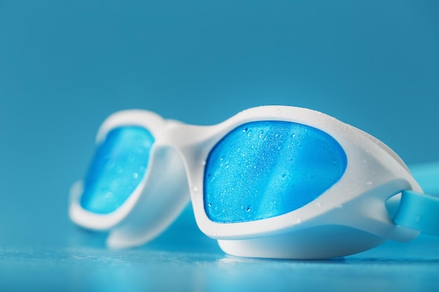 Photo lunettes de natation blanches sur fond bleu