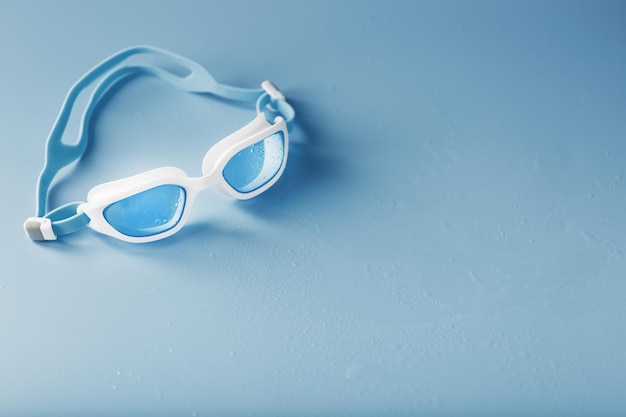 Lunettes de natation dans un cadre blanc avec sur un bleu