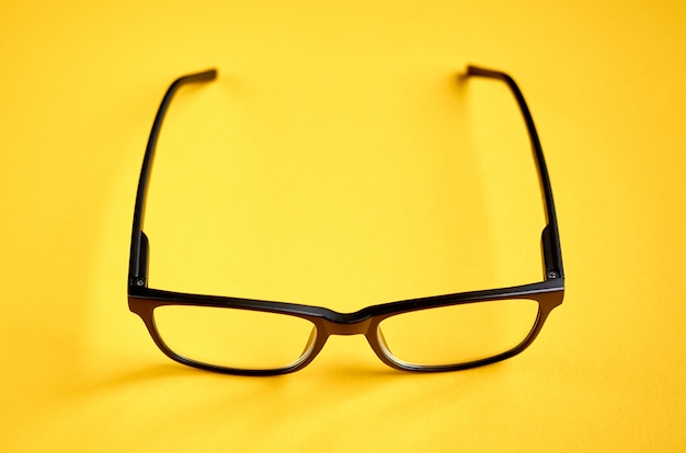 Lunettes noires sur une surface jaune, lunettes de vue.