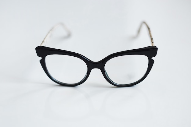 Lunettes noires vintage sur fond blanc.