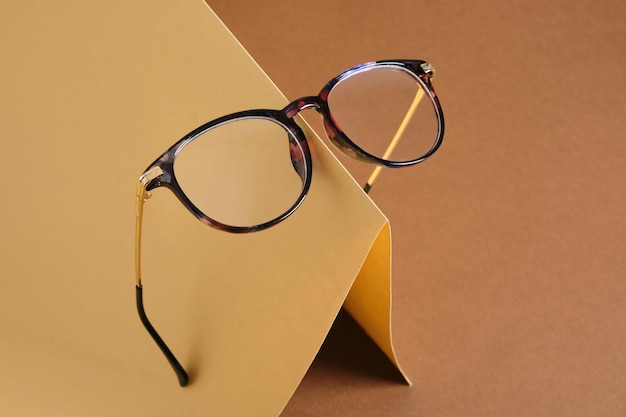 Lunettes sur papier concept de vision de fond marron et beige