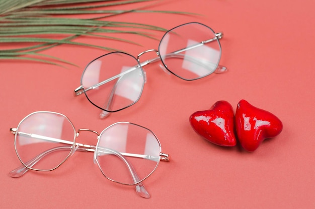 Photo des lunettes pour la vision sur un fond rouge avec des cœurs faisant la publicité d'un magasin d'optique