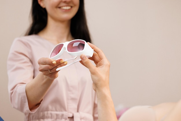 Lunettes de protection sur l'équipement d'épilation au laser dans le concept de cosmétologie d'épilation du centre de spa