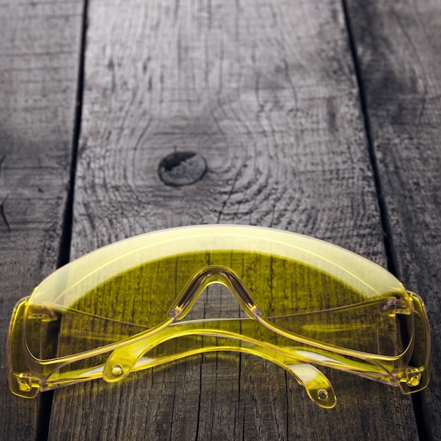 Lunettes de protection oculaire pour travaux de réparation et de construction, sur une surface en bois