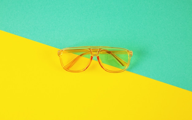 Lunettes de soleil fahionables jaunes sur fond de papier de couleur abstraite