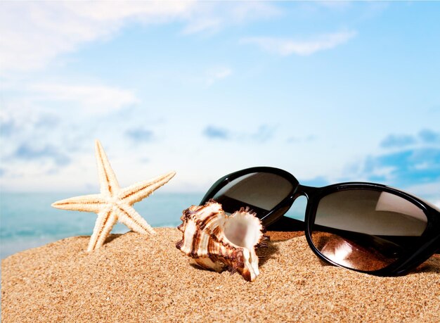 Lunettes de soleil sur fond de plage de sable