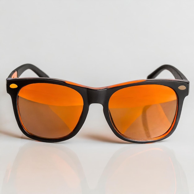 Des lunettes de soleil avec des lentilles orange sur un fond blanc
