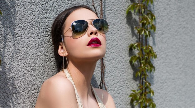 Lunettes de soleil à la mode. Fille modèle avec des lunettes en plein air. Style de lunettes vogue femme sensuelle.