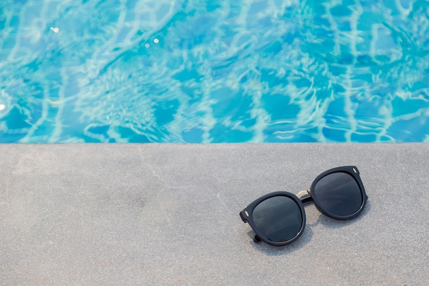 Lunettes de soleil de mode près de l&#39;arrière-plan de la piscine