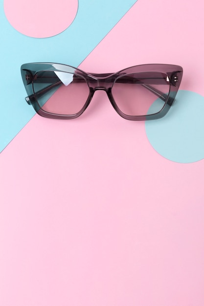 Lunettes de soleil mode sur table créative tendance rose et bleu