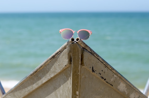 Lunettes de soleil roses contre le soleil sur un bateau près de la mer