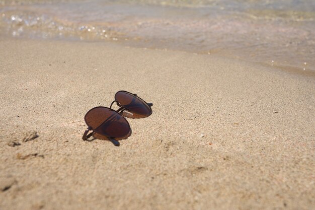 Lunettes de soleil sur le sable pour le concept de vacances d'été.