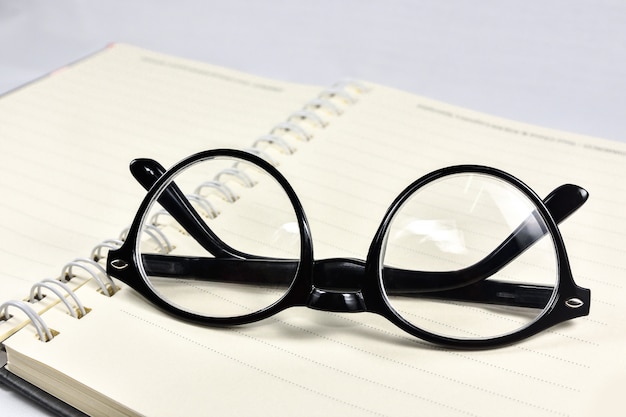 Des lunettes de travail et des livres de lecture sont placés sur le livre.