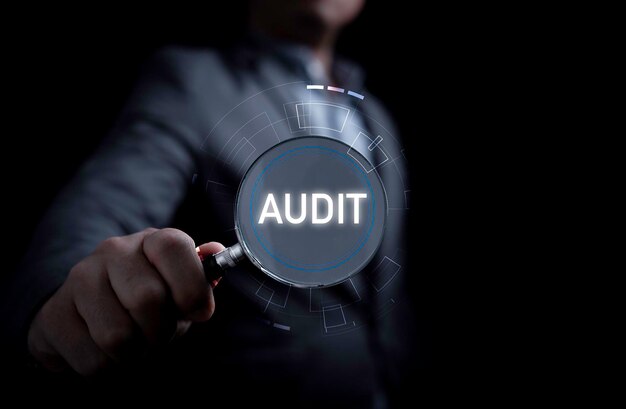 Photo lupe à main avec la formulation de l'audit pour le concept d'audit de qualité et de certificat iso