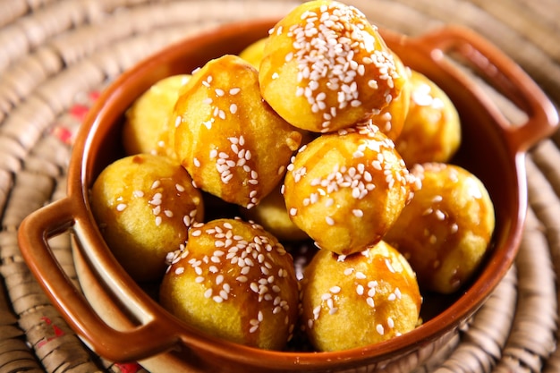 Luqaimat ou Lotus Gaimat boules sucrées aux graines de sésame servies dans un plat isolé sur la vue de dessus de table du dessert arabe