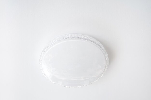 Photo un lustre blanc rond ordinaire sur un plafond blanc