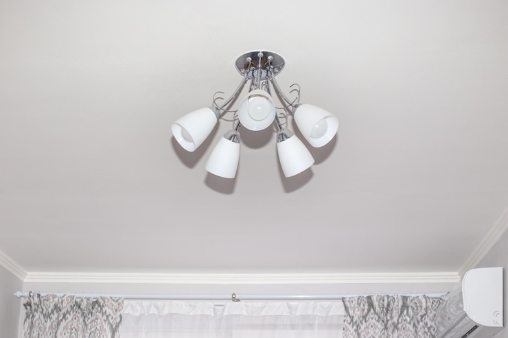 Photo lustre à cinq bras sur un plafond blanc dans une petite pièce éclairage de pièce