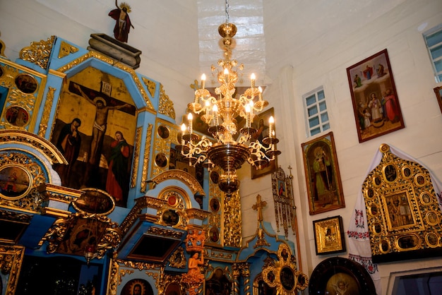 Lustre en or avec bougies dans le temple. Autel dans l'église orthodoxe.