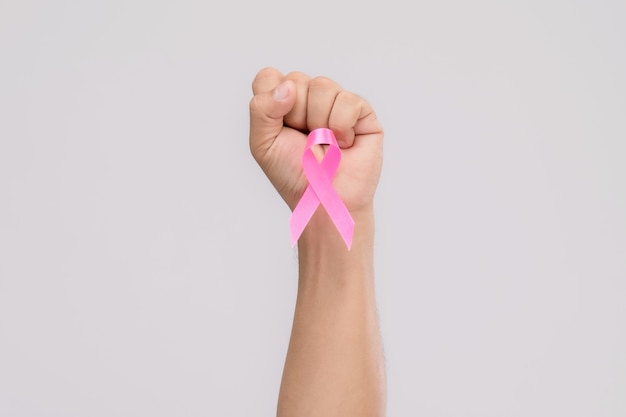 Lutte pour le concept de cancer du sein: les gens la main avec un ruban rose le symbole de la campagne contre le cancer du sein