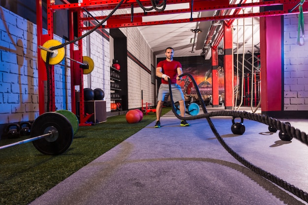 Photo lutter contre les cordes homme à l'exercice d'entraînement de gym