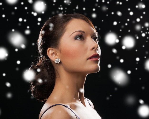 luxe, vip, vie nocturne, fête, noël, noël, concept du nouvel an - belle femme en robe de soirée portant des boucles d'oreilles en diamant