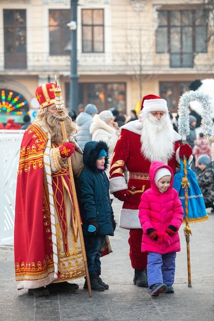 Photo lviv ukraine 26 décembre 2021 enfants prenant des photos avec le père noël et saint mikolay pendant les vacances de noël