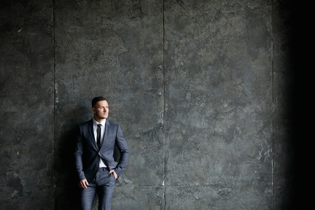 M. Beau. Jeune bel homme en costume et cravate dans un bureau loft moderne