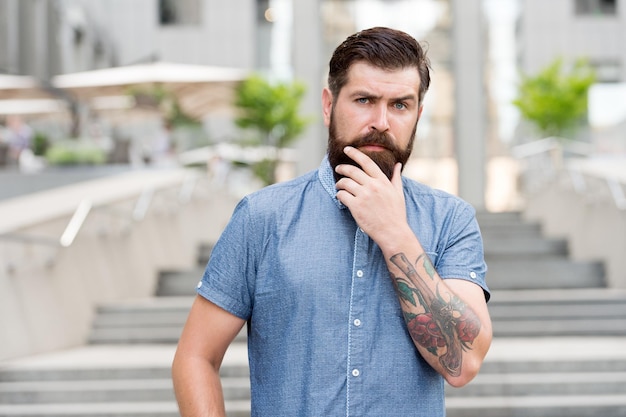 Ma barbe mon look Homme barbu toucher barbe urbain extérieur Hipster porter une barbe et une moustache non rasées Produits pour la croissance de la barbe Barbershop Salon de coiffure Toilettage pour hommes Gardez les poils et la peau du visage doux