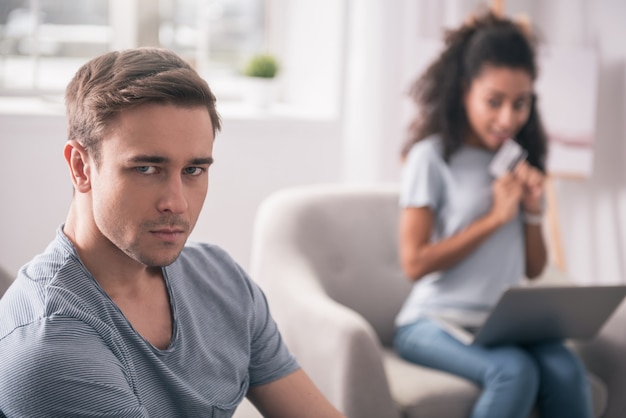 Ma femme est accro au shopping. Homme sérieux triste se sentir malheureux tout en ayant une femme accro du shopping