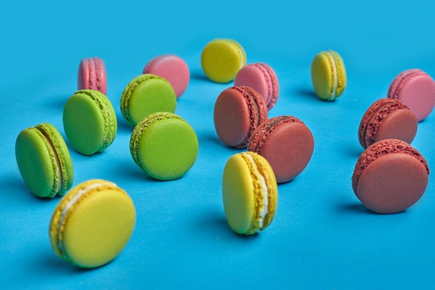 Macaron coloré ou confiserie à base de meringue sucrée macaron sur fond bleu Espace de copie libre