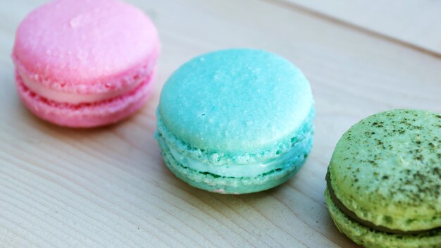 Macaron de gâteau coloré ou macaron sur fond en bois.