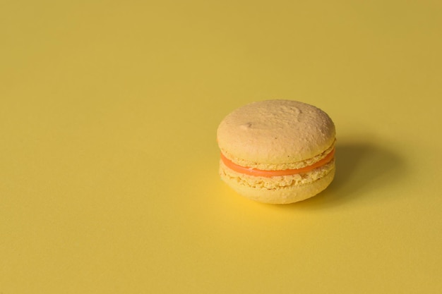 Un macaron jaune sur fond jaune minimaliste.