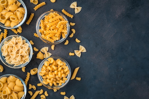 Macaroni de différents types sur fond sombre.