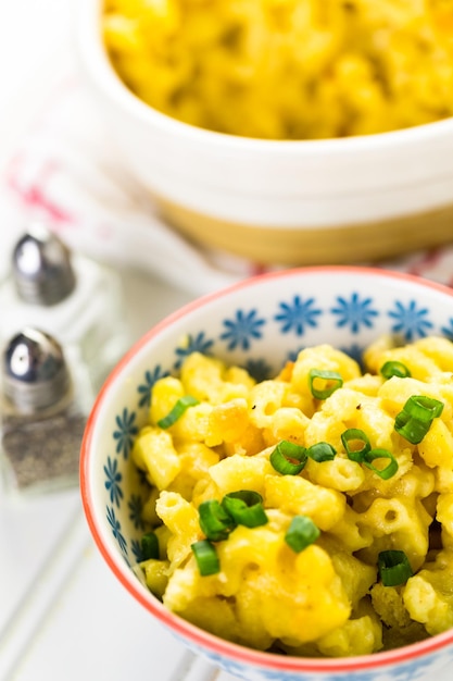 Macaroni et fromage cuits au four avec des billes de chapelure et garnis de ciboulette.