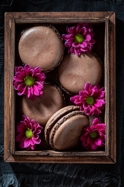 Photo macarons au chocolat noir et maison aux fleurs violettes