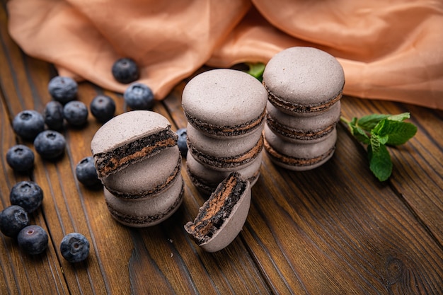 Photo macarons aux fruits rouges sur une table en bois