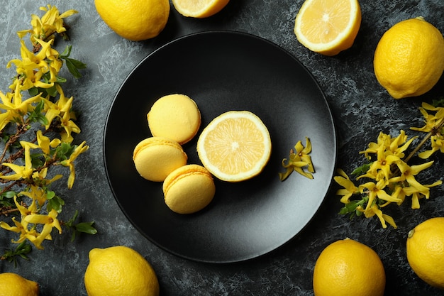 Macarons, citrons et fleurs sur fond smokey noir