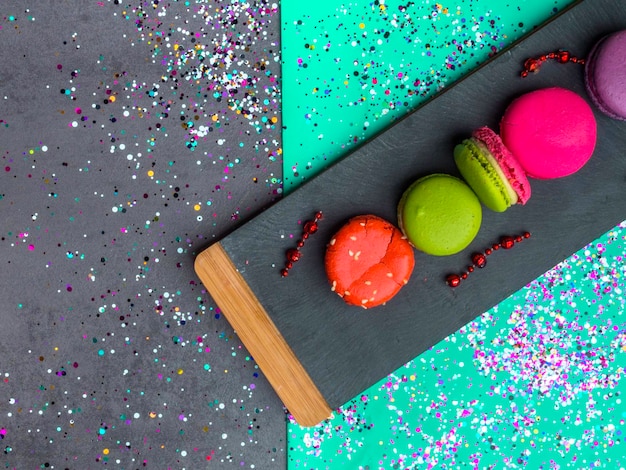 Macarons colorés à l'ardoise de pierre sur fond de couleur vert menthe à la mode Macarons sucrés aux baies Vue de dessus