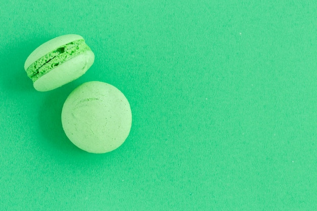 Macarons colorés ou biscuits macarons sur fond vert