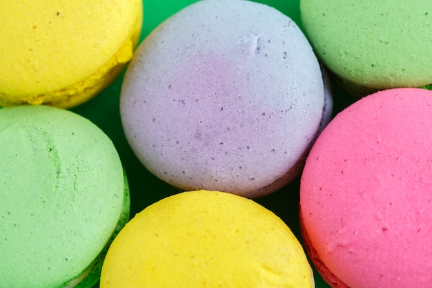 Macarons colorés ou biscuits macarons sur fond vert