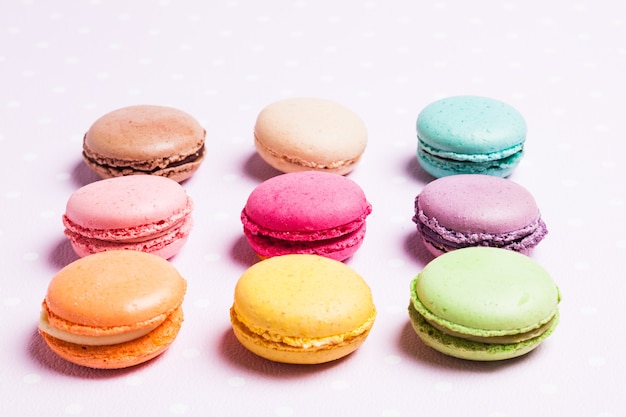 Macarons colorés - dessert français sur serviette rose à pois