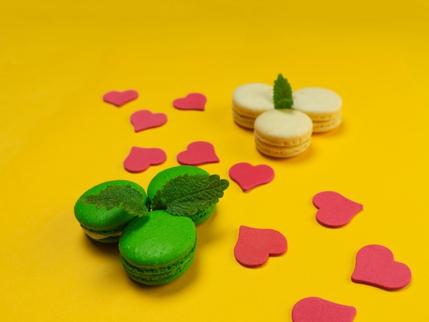 Macarons colorés sur fond jaune. Concept pour les vacances. Espace de copie