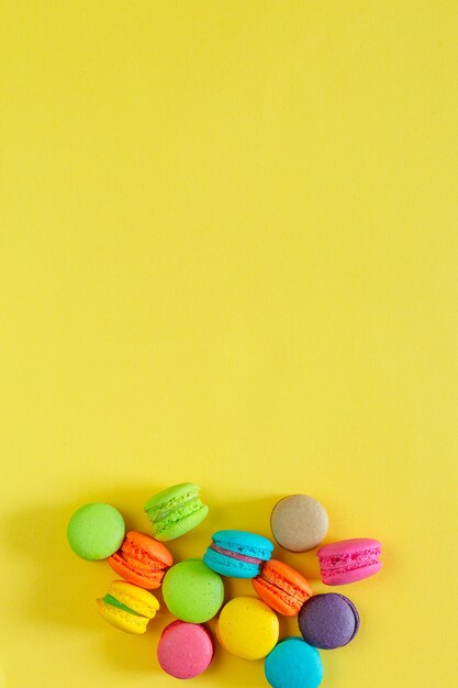 Macarons colorés sucrés sur fond jaune