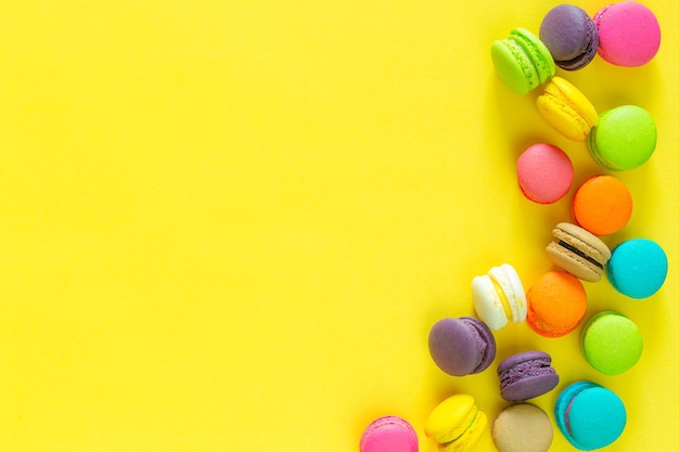 Macarons colorés sucrés sur fond jaune