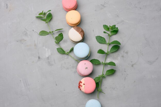 Macarons cuits au four avec différentes saveurs sur fond de ciment gris, vue de dessus