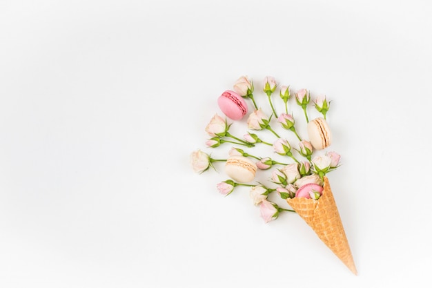 macarons dans un cône de gaufres et roses roses