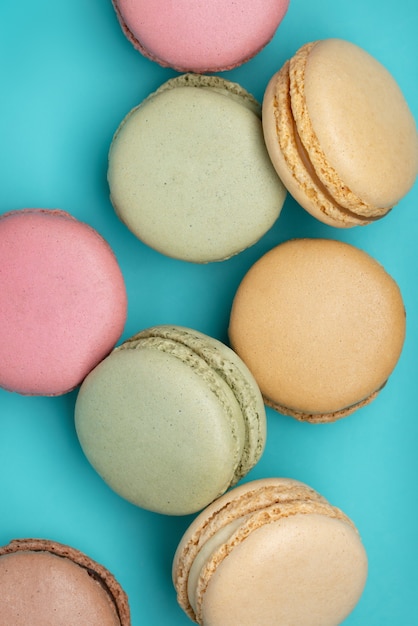 Macarons de différentes couleurs sur fond bleu foncé Vue de dessus en gros plan