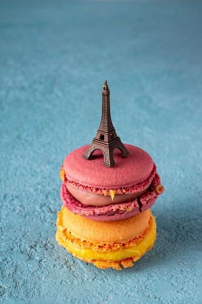 Macarons avec une figurine de la Tour Eiffel sur fond bleu