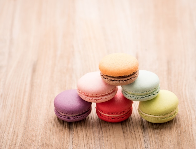 Macarons français colorés sur fond en bois