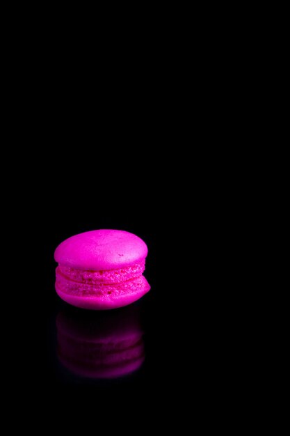 Macarons français colorés sur fond noir.